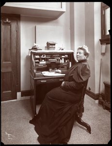 Porträtt av en oidentifierad kvinna vid ett skrivbord på ett kontor i New York, 1904 (silvergelatintryck)